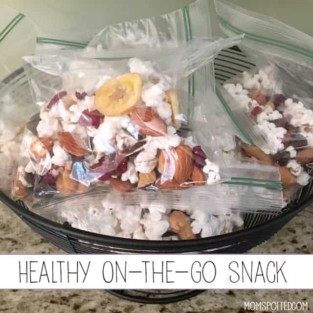 A plastic container filled with different types of food, with Trail mix for healthy on the go snack for toddler