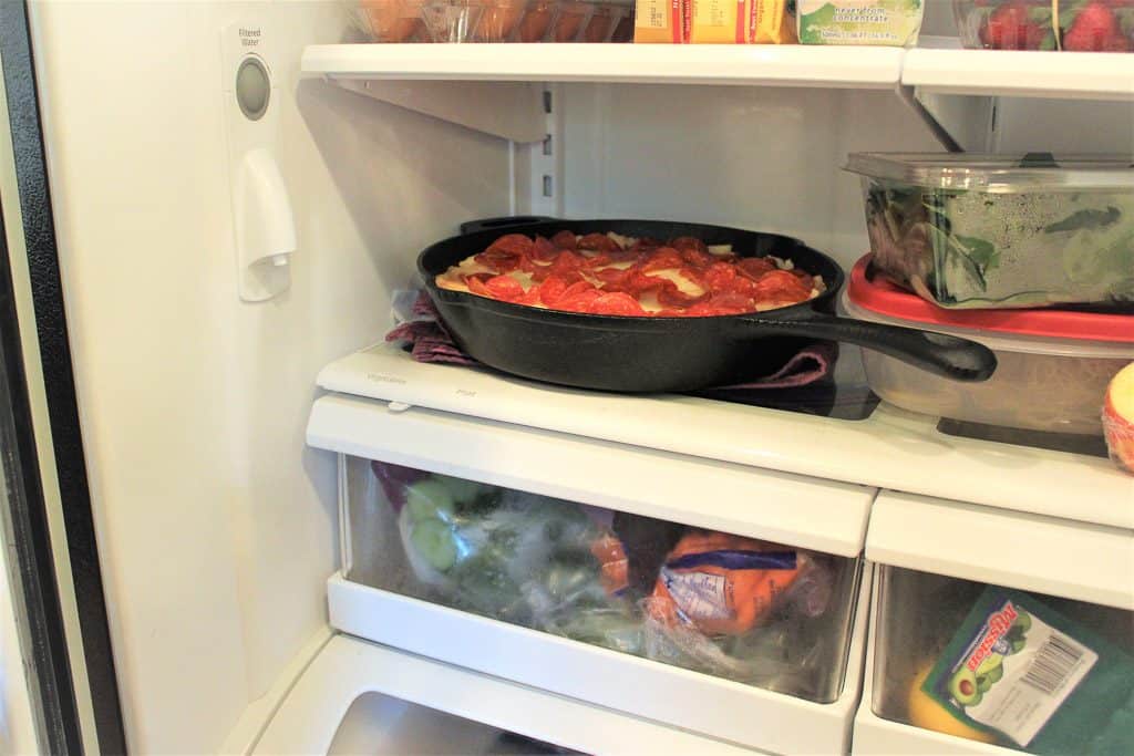 An open refrigerator filled with food, with Pizza and Pie