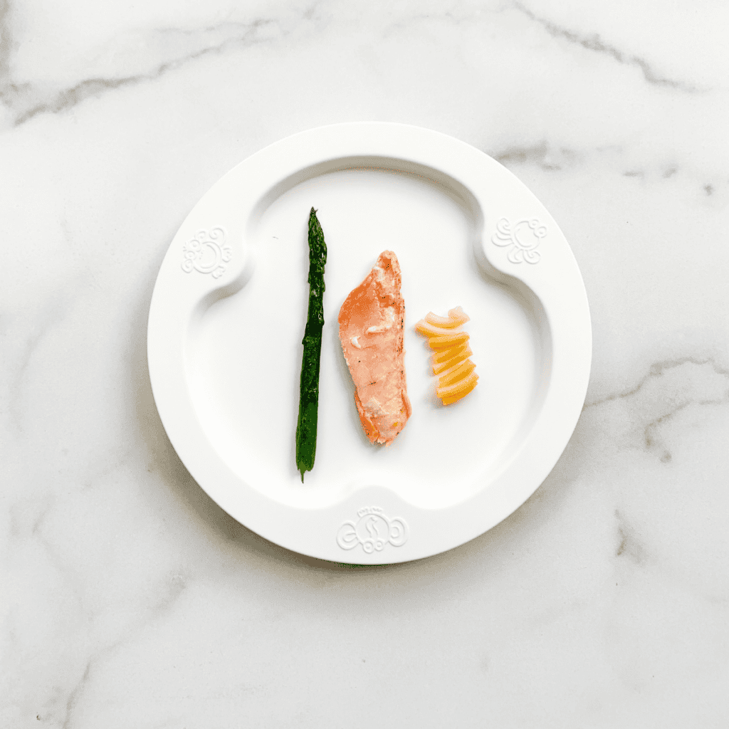 Salmon, asparagus on a plate for feeding baby 