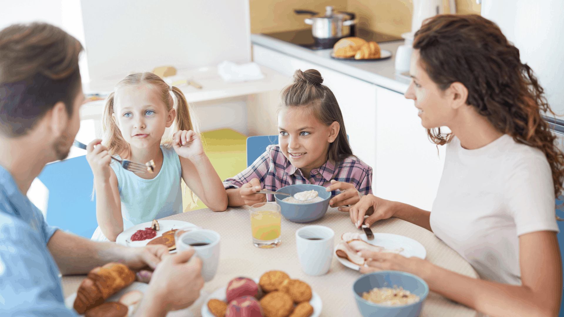 A group of kids sitting at a table with a plate of food