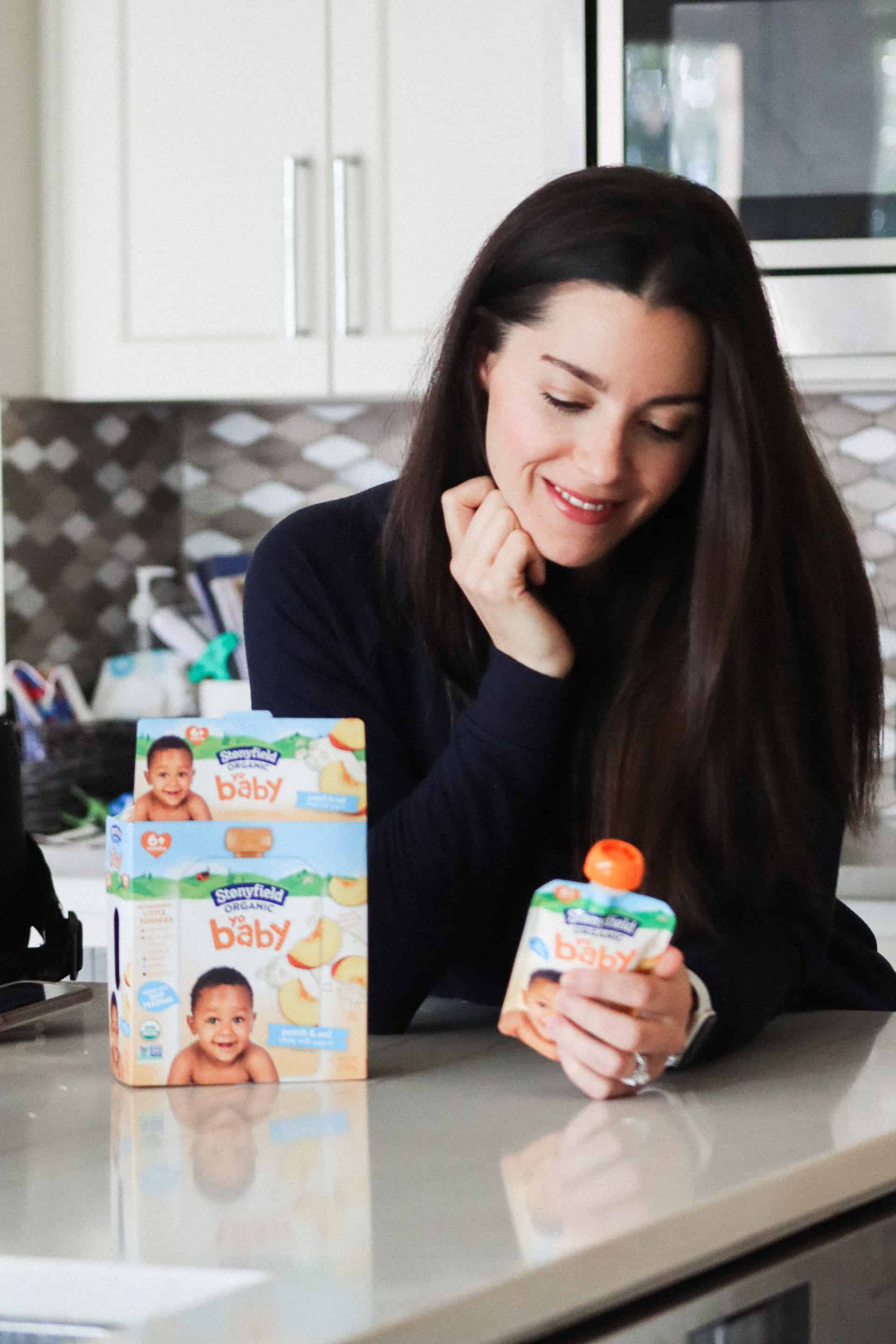 woman in kitchen looking at stonyfield baby food