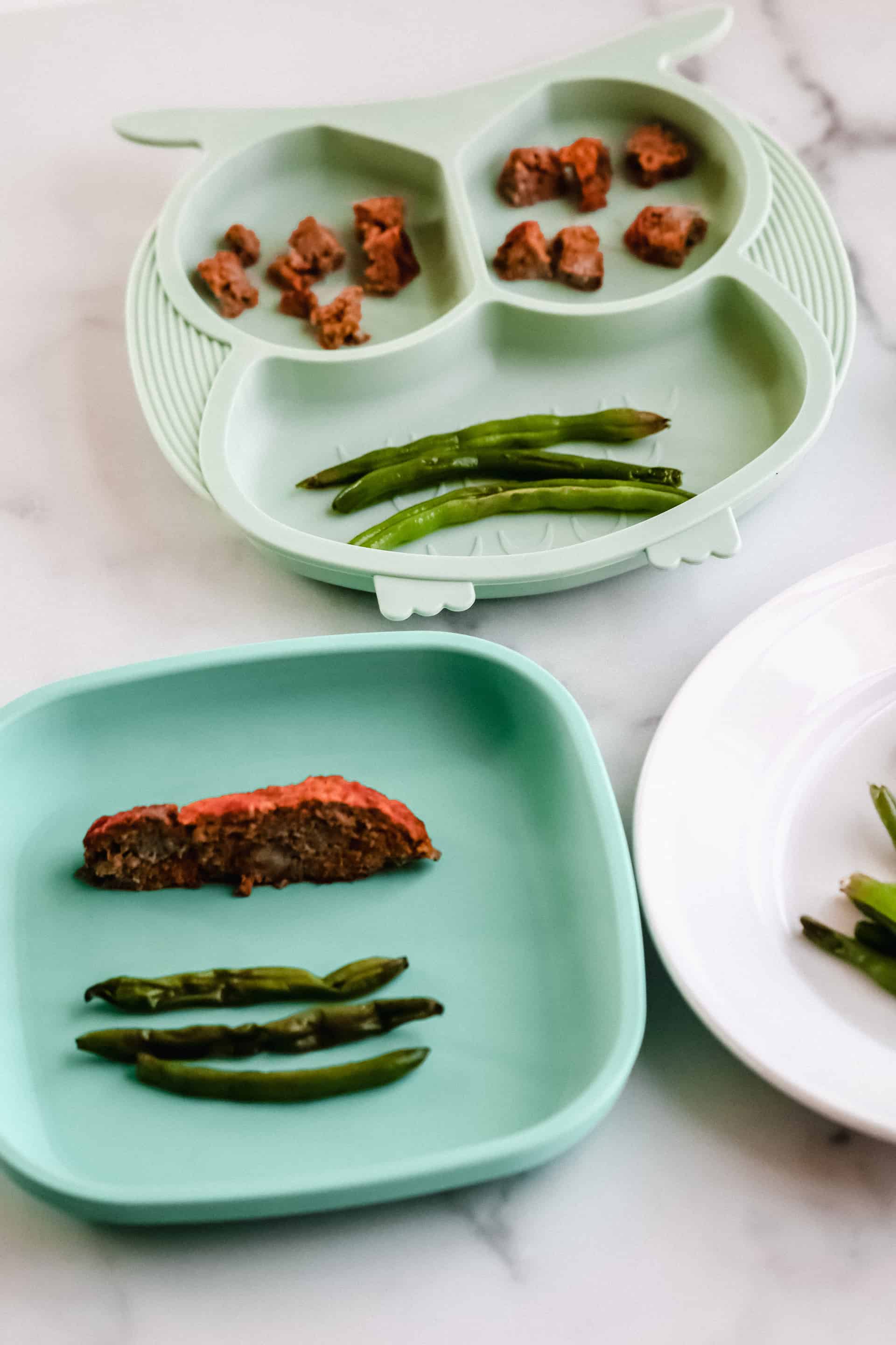 A plate of food on a table, with Mini meatloaf and green beans