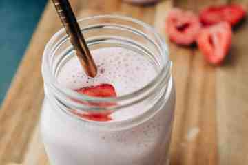 strawberry smoothie in mason jar with staw