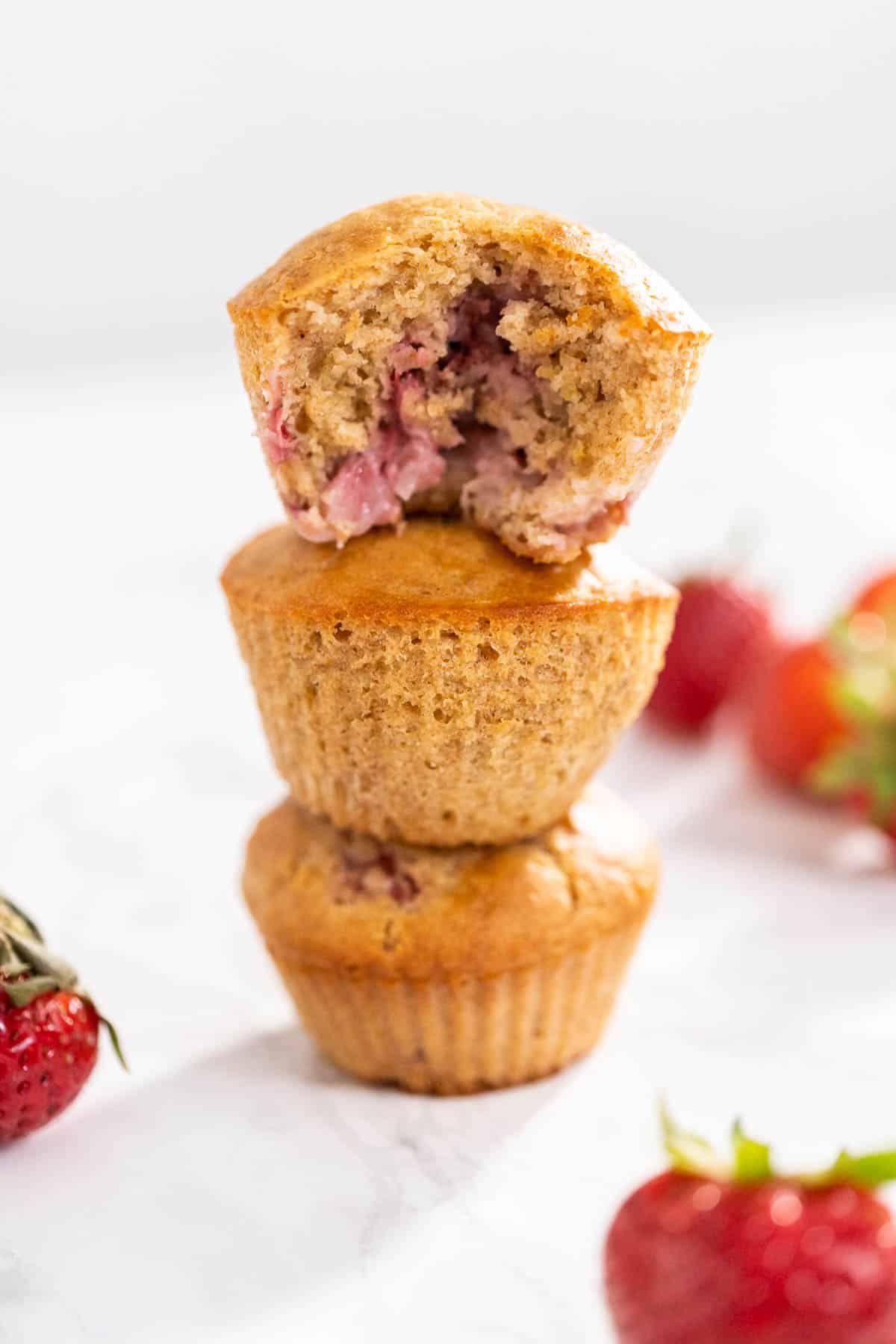 3 strawberry muffins stacked on top of each other with a white background 