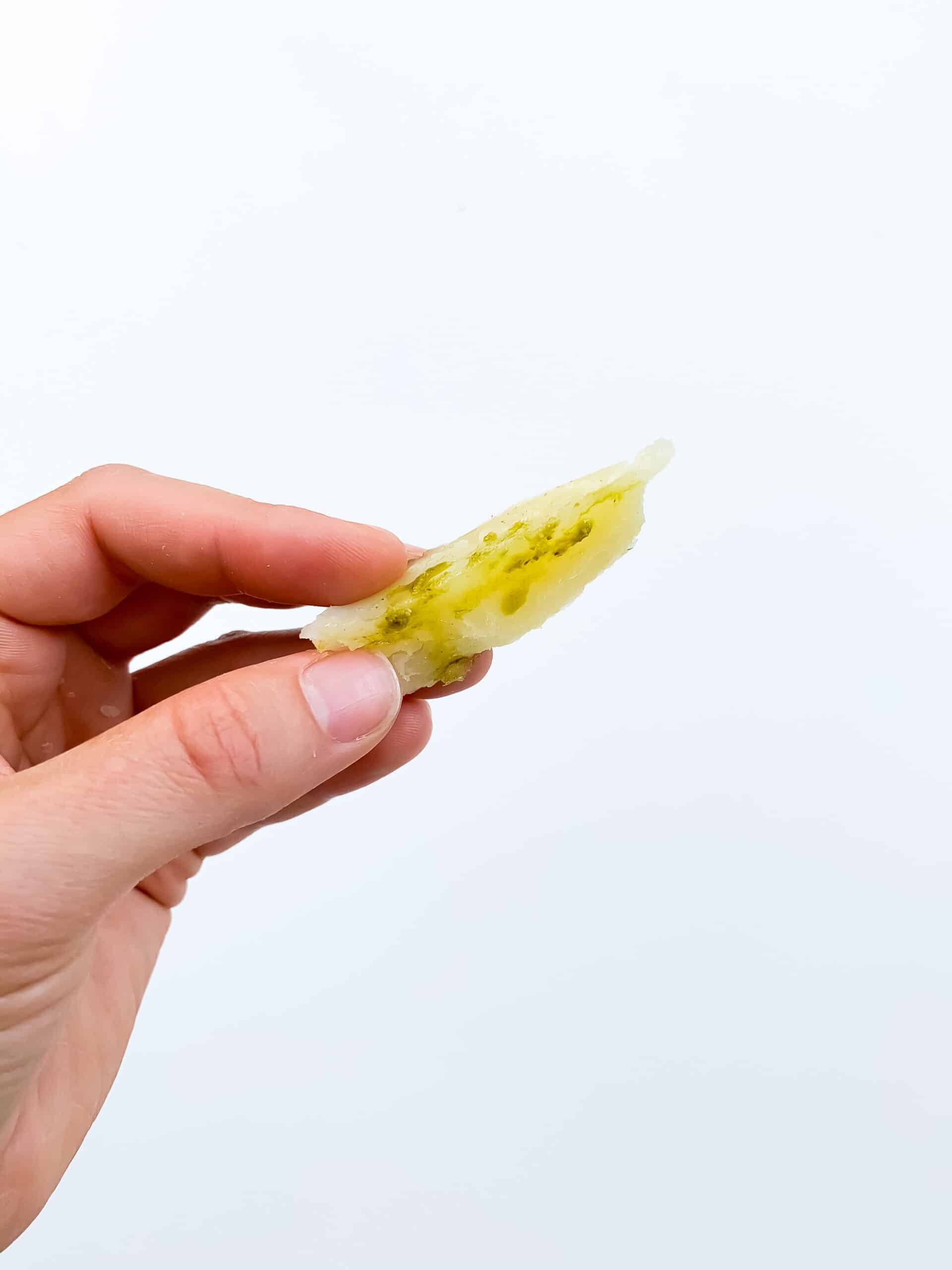 baked potato wedge with olive oil and pesto for baby with white background