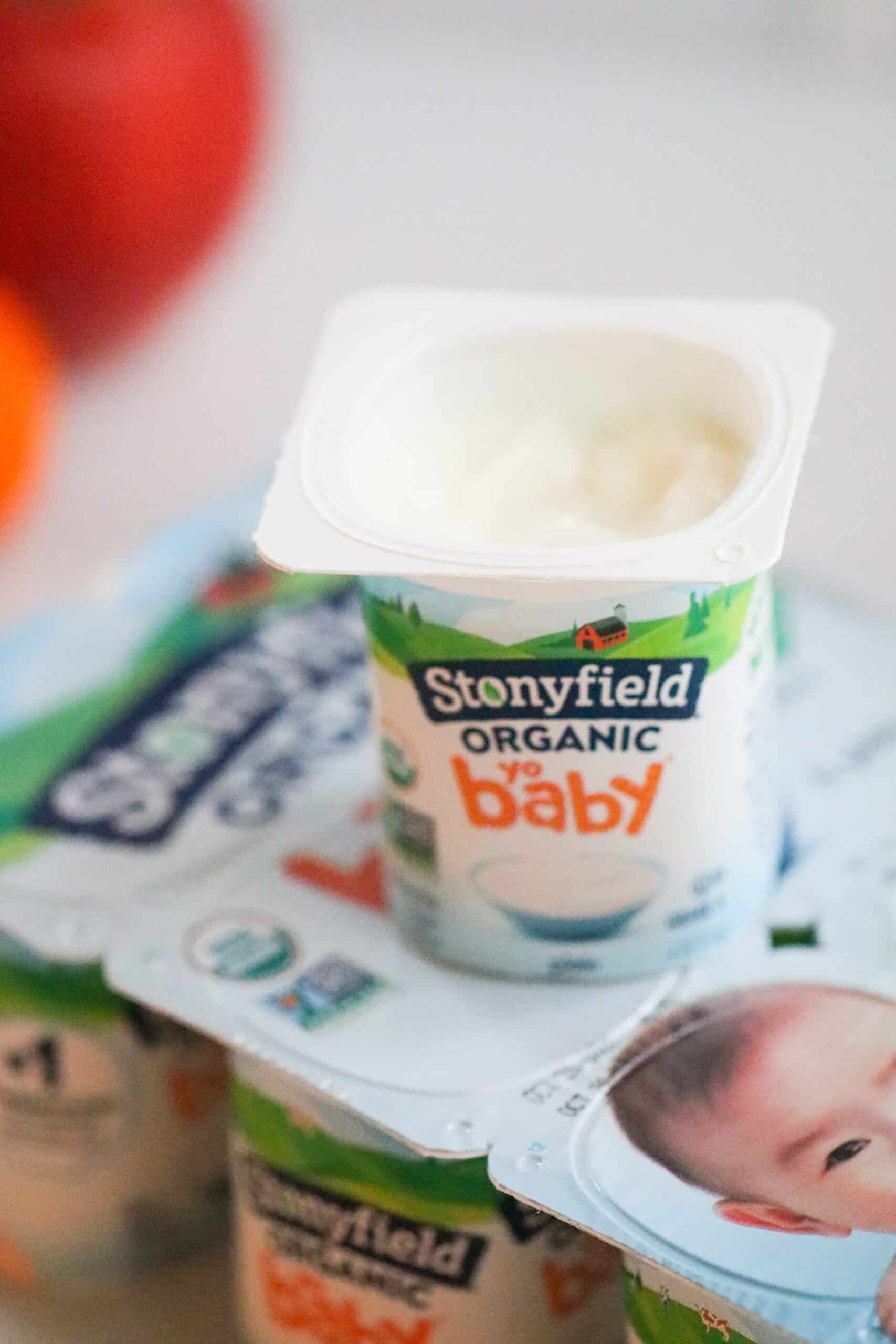 Package of stonyfield yogurts and one open on top