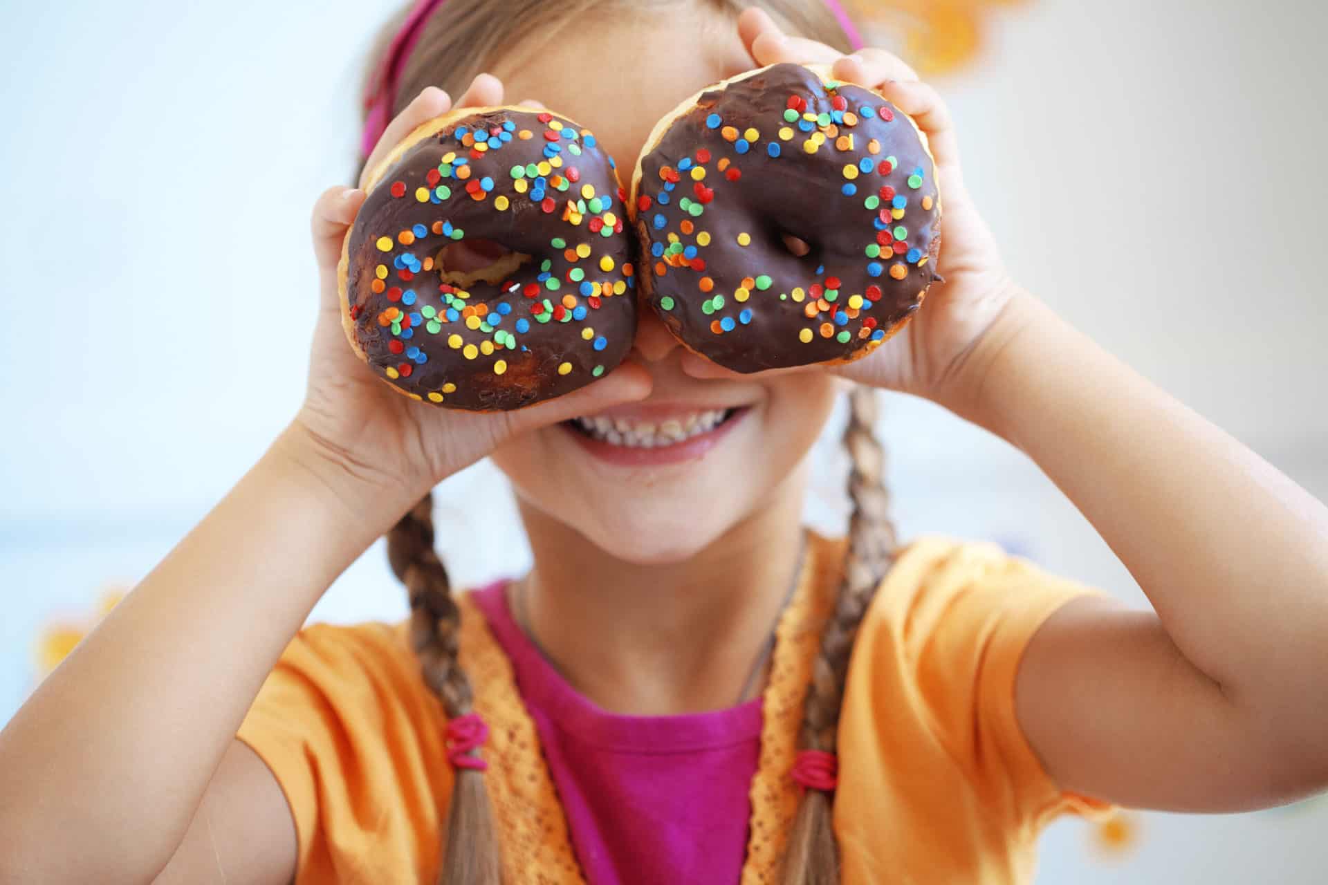 cute girl holding two donuts