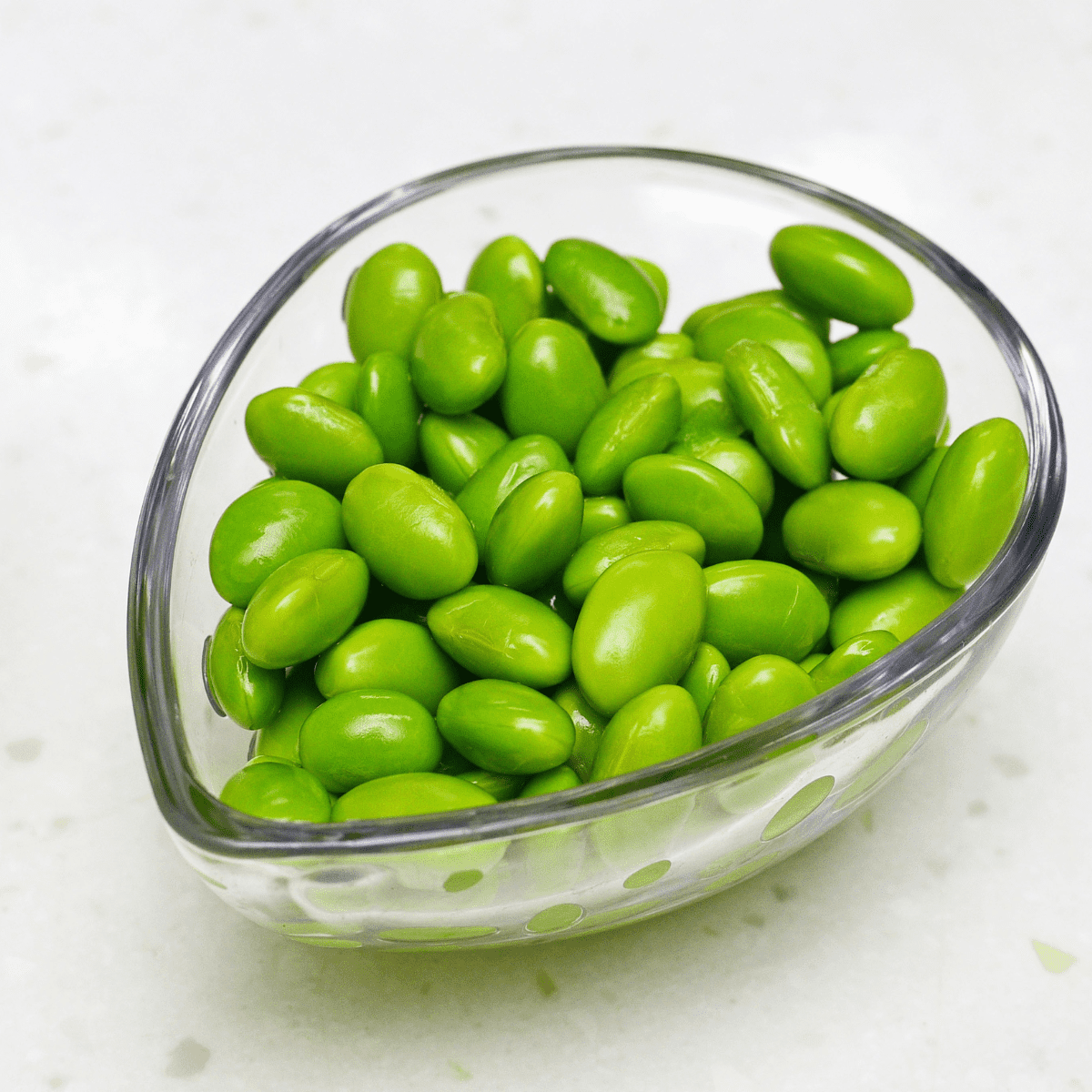 Clear bowl filled with shelled edamame 