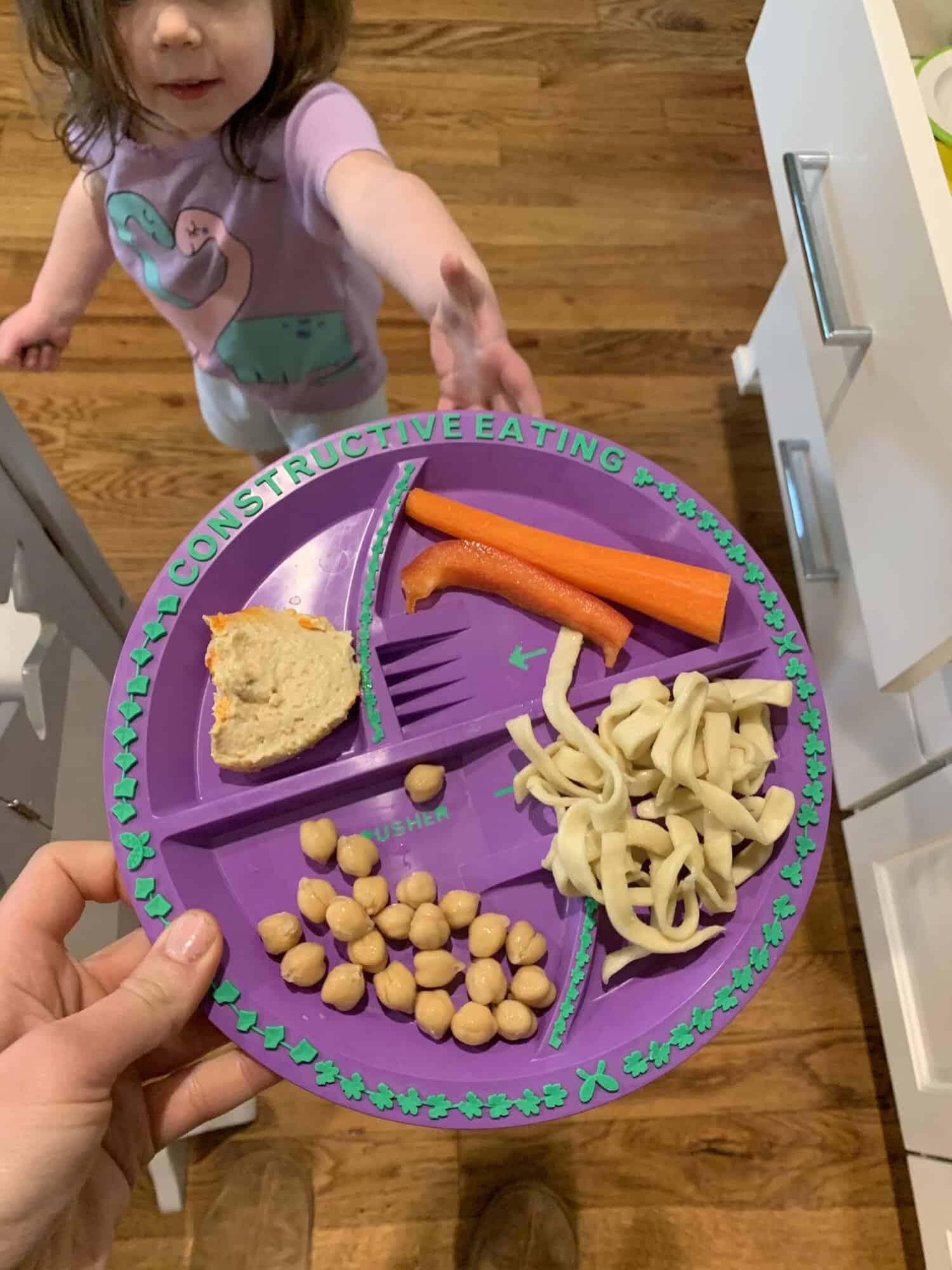 purple toddler divided plate with chickpeas carrots noodles and bread for lunch