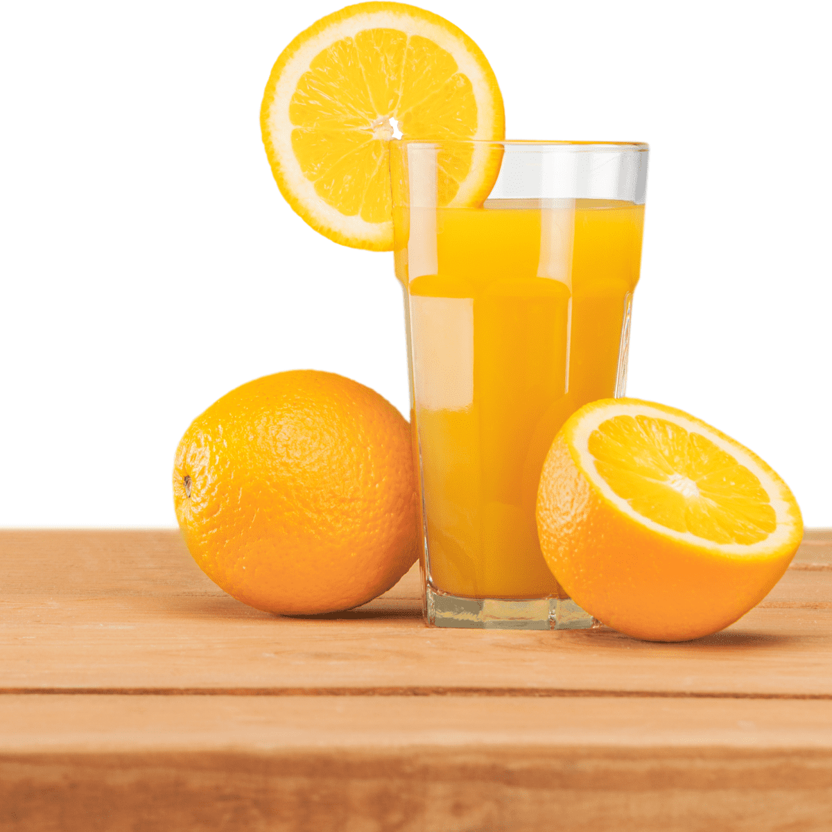 White background, wooden tabletop, glass of orange juice with orange slice on the rim and oranges on tabletop