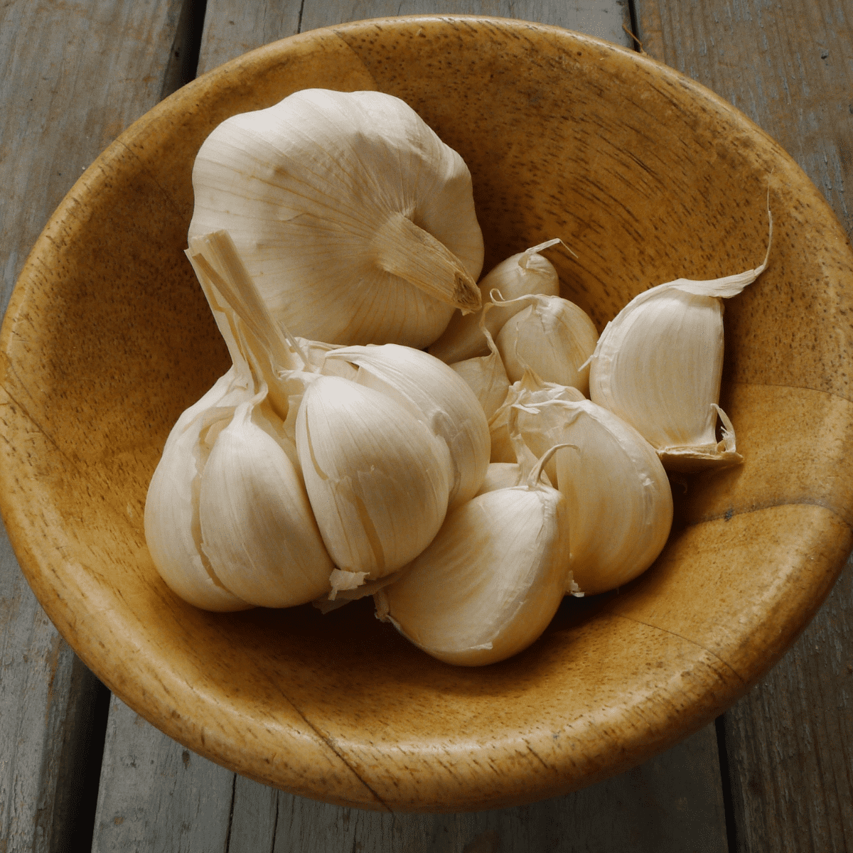 Wooden bowl with cloves of garlic