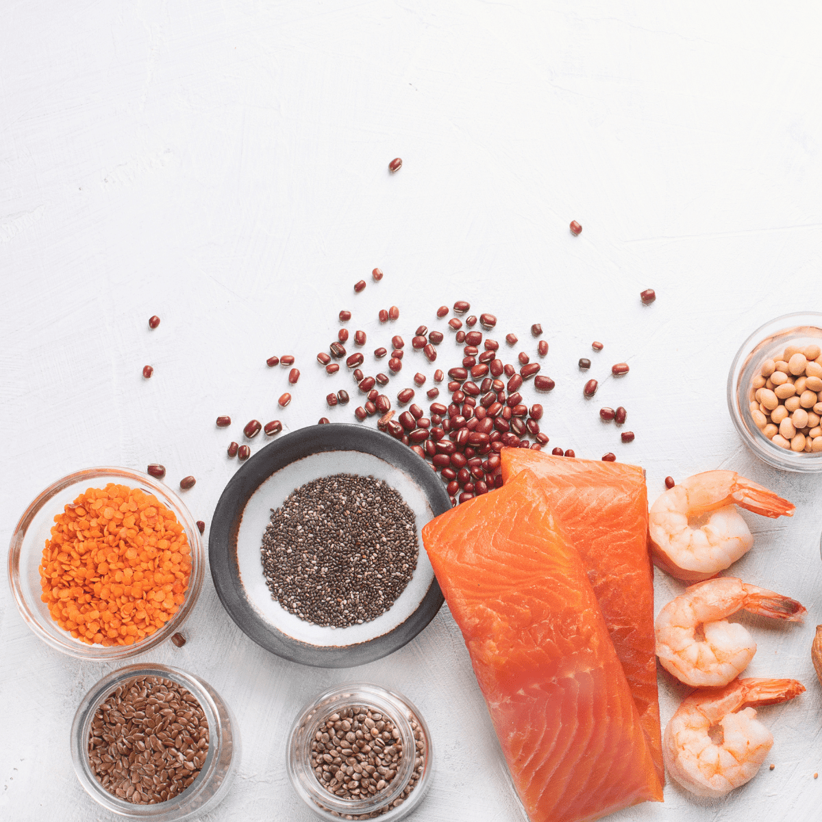 White background with collage of omega-3 foods: salmon, shrimp, beans, flaxseed 