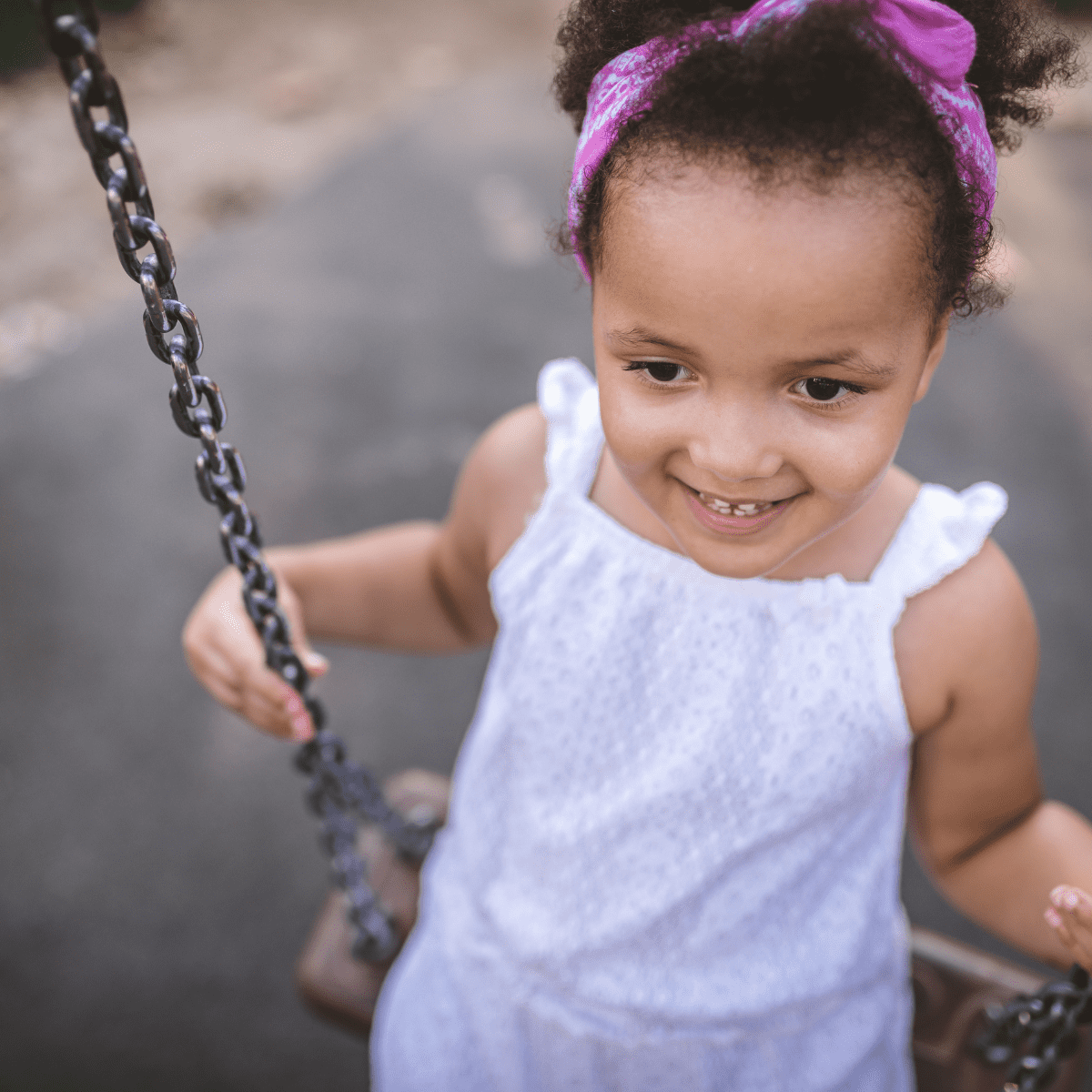 Toddler girl swinging outside