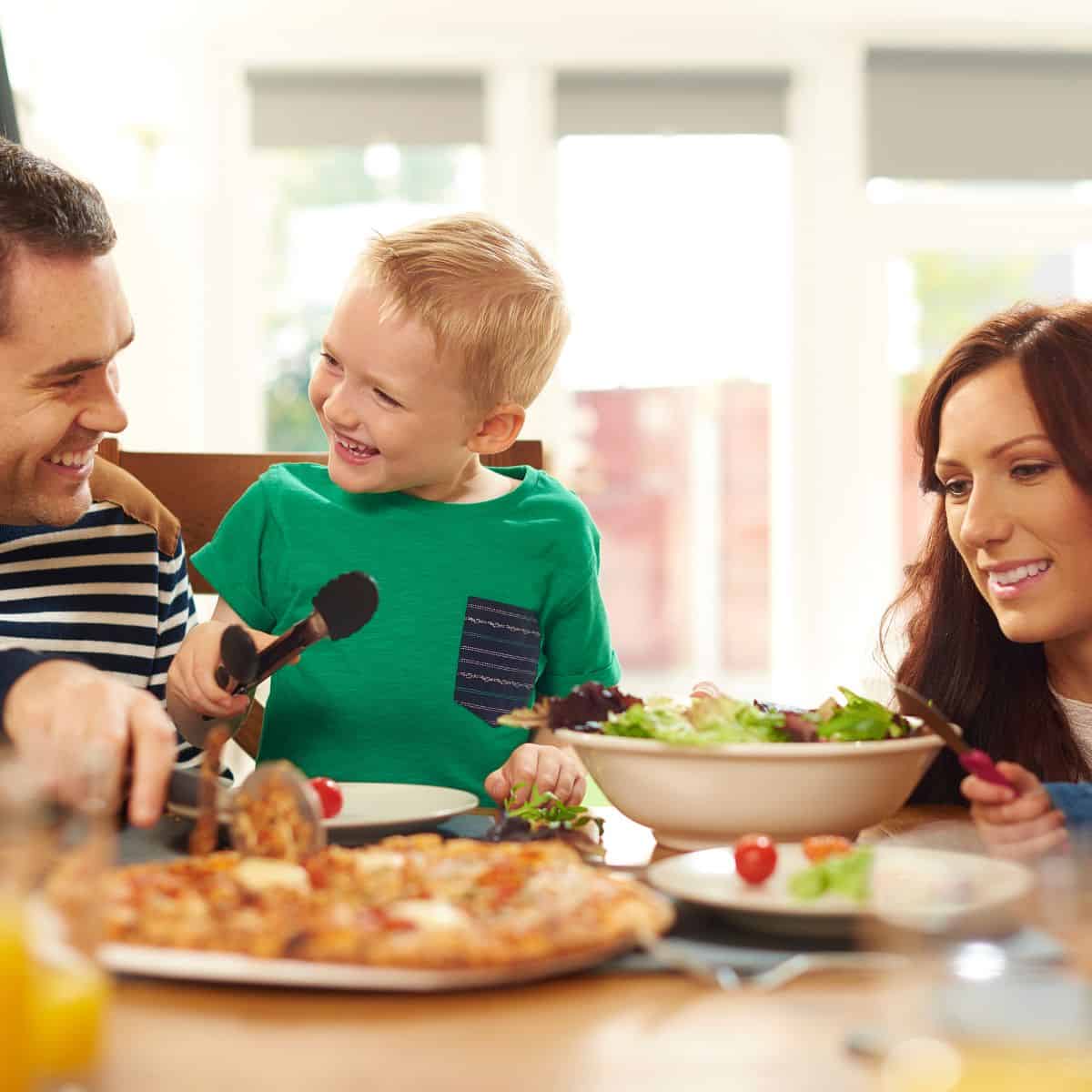 Mom, dad and son eating dinner at the table together