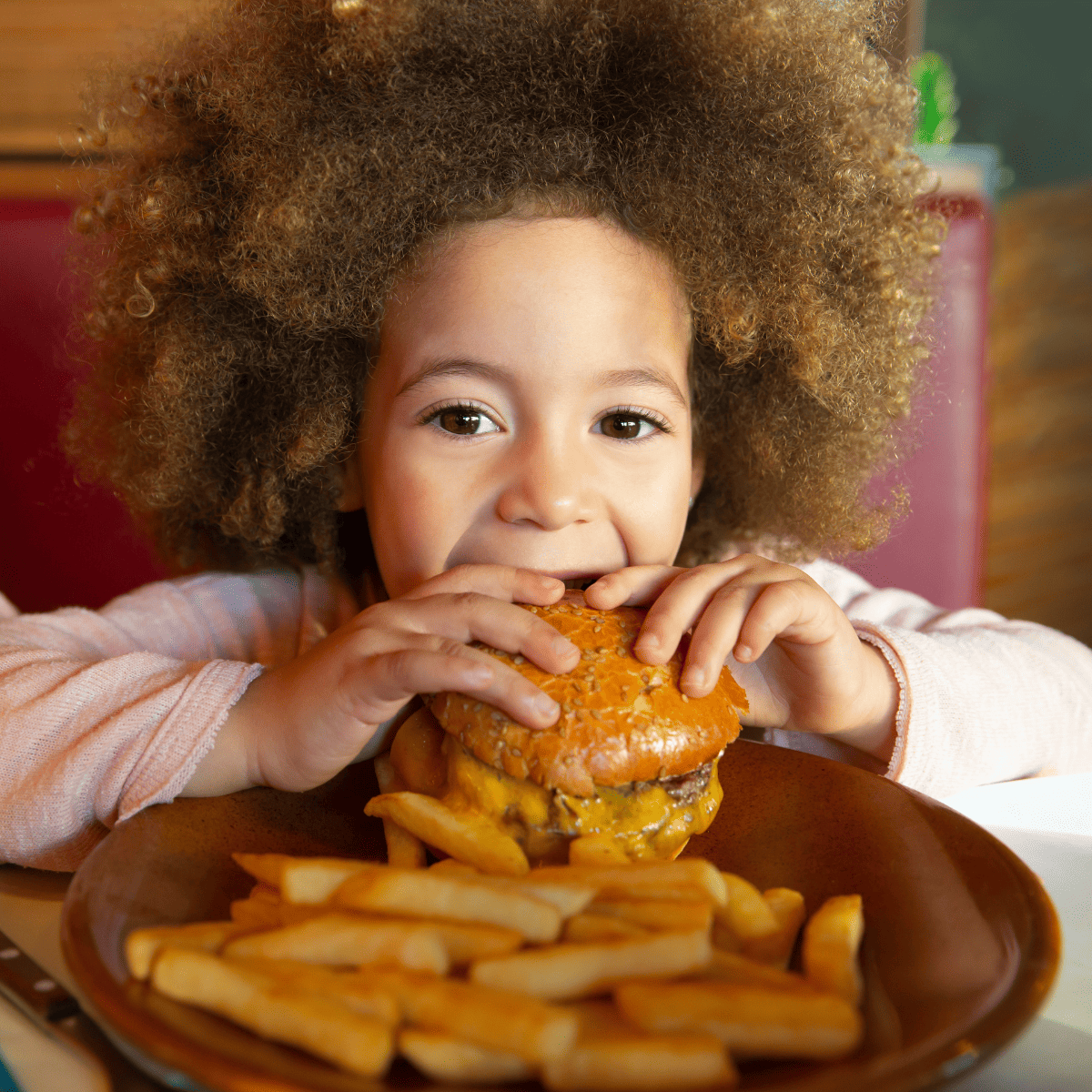 child eating hamburger and french fries