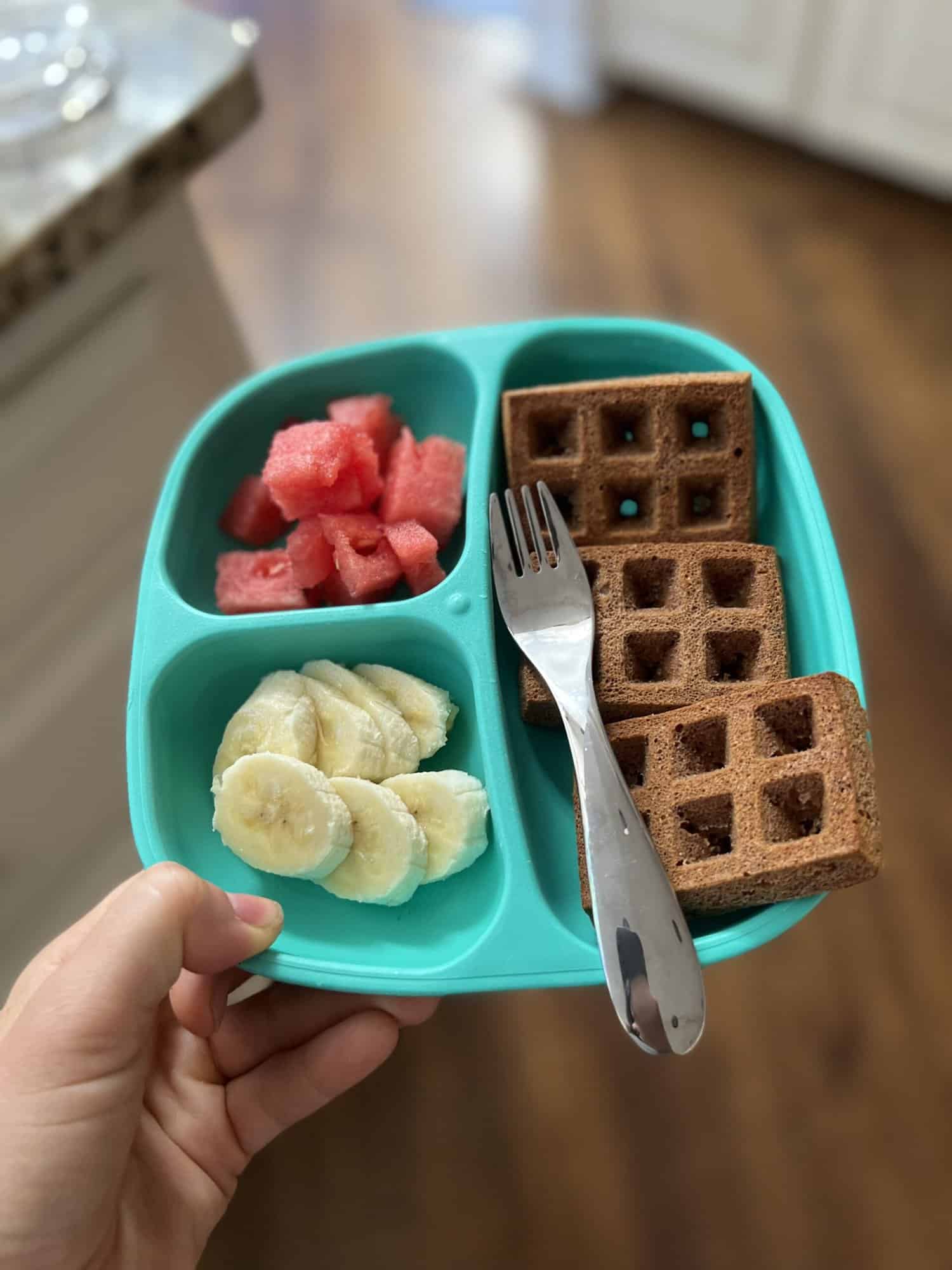 breakfast toddler plate with whole wheat waffles, banana slices, and watermelon cubes