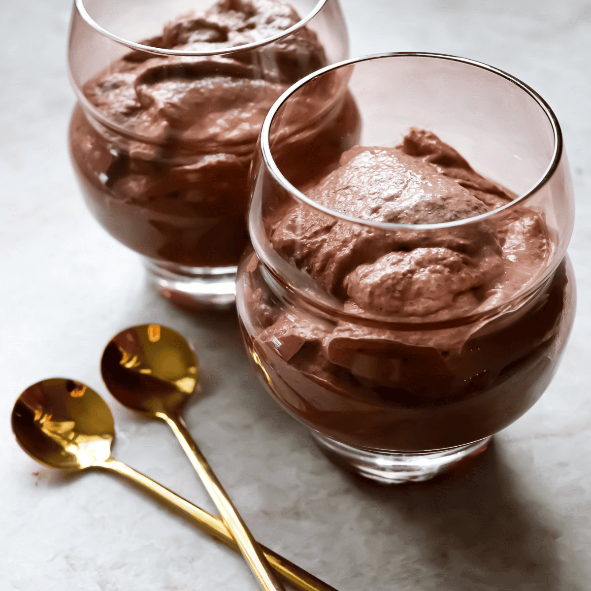 chocolate chia seed pudding cups with gold spoons