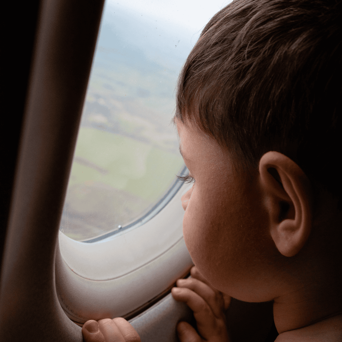 little boy looking out airplane window