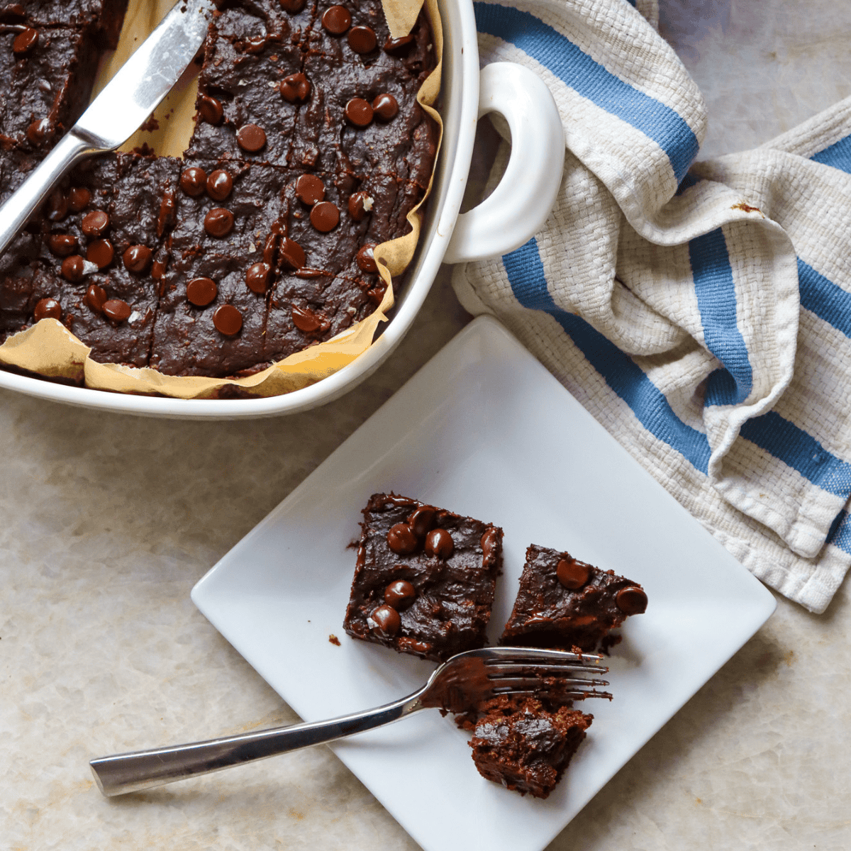 birds eye view shot of pan of brownies with two brownies plated