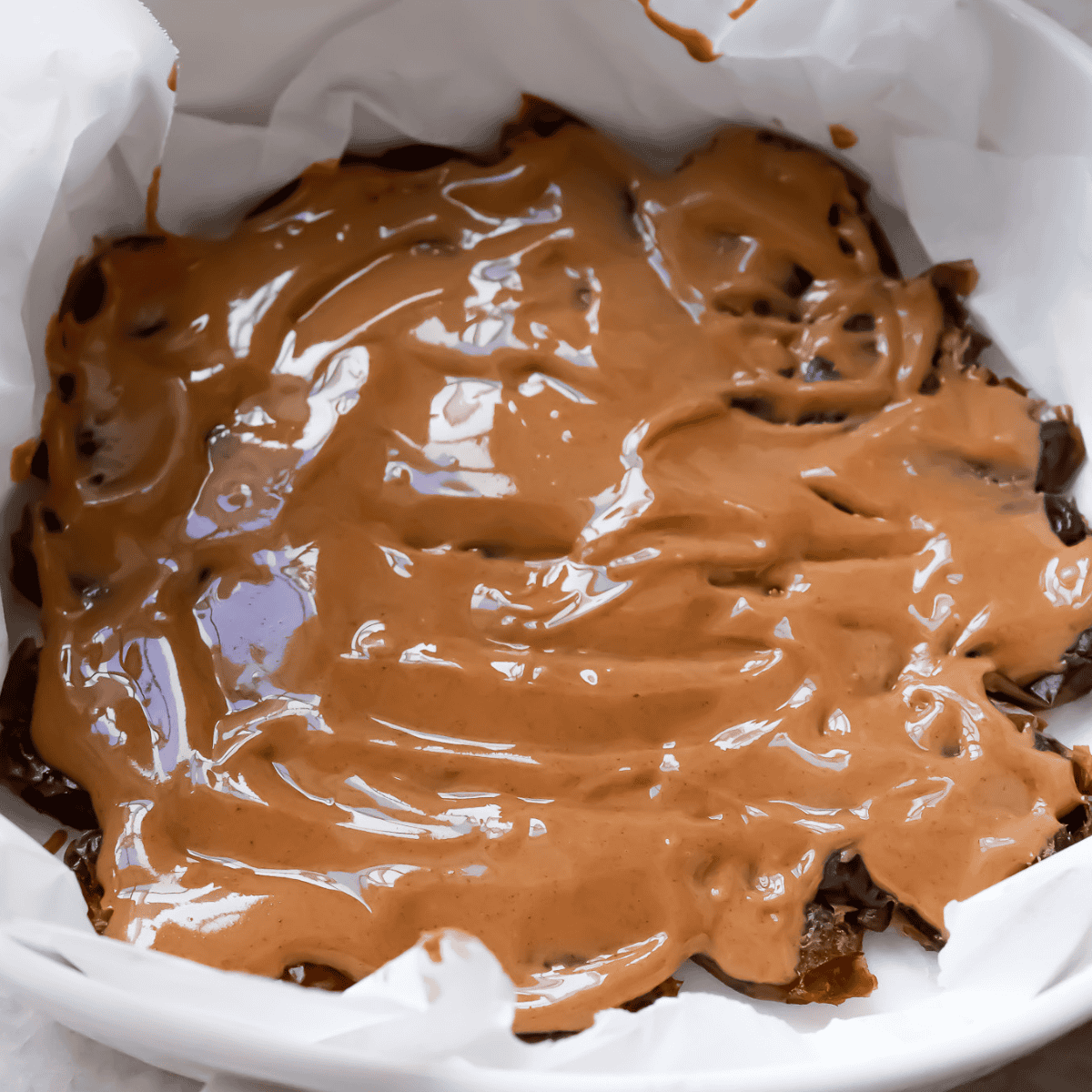 nut butter layered on top of dates in the pan